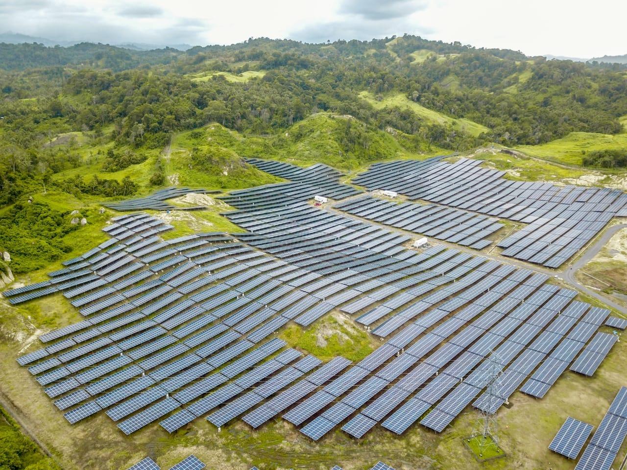 Aerial view of a large installation set against forested tropical hills