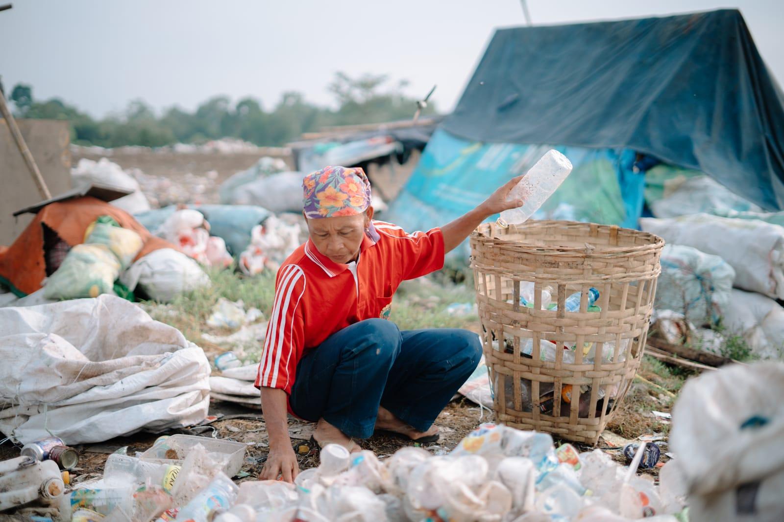 Pekerja sampah memilah botol plastik yang dapat didaur ulang di lokasi pembuangan terbuka