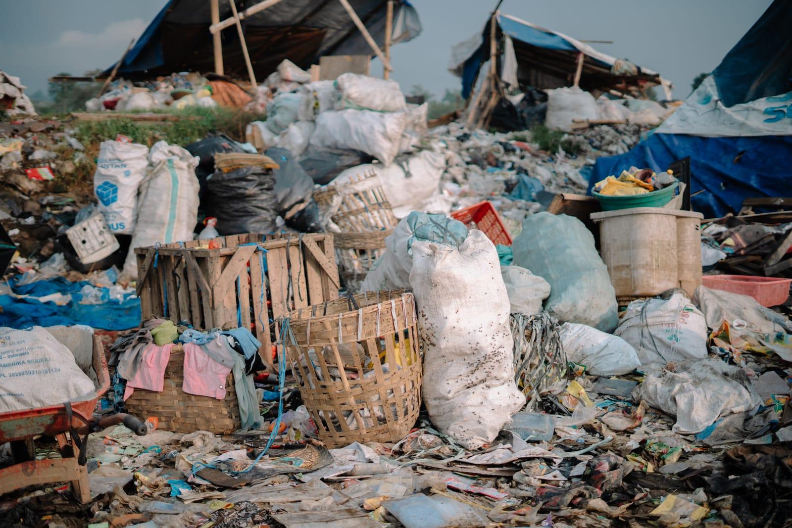 Keranjang dan karung sampah daur ulang yang telah dipilah menumpuk di lokasi pembuangan terbuka